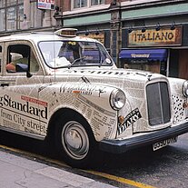 Taxi mit Zeitungsaufdrucken