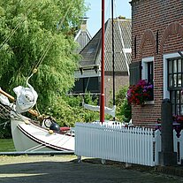 Boot schaut hinter Haus vor