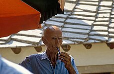 alter Mann lutscht an seiner Pfeife